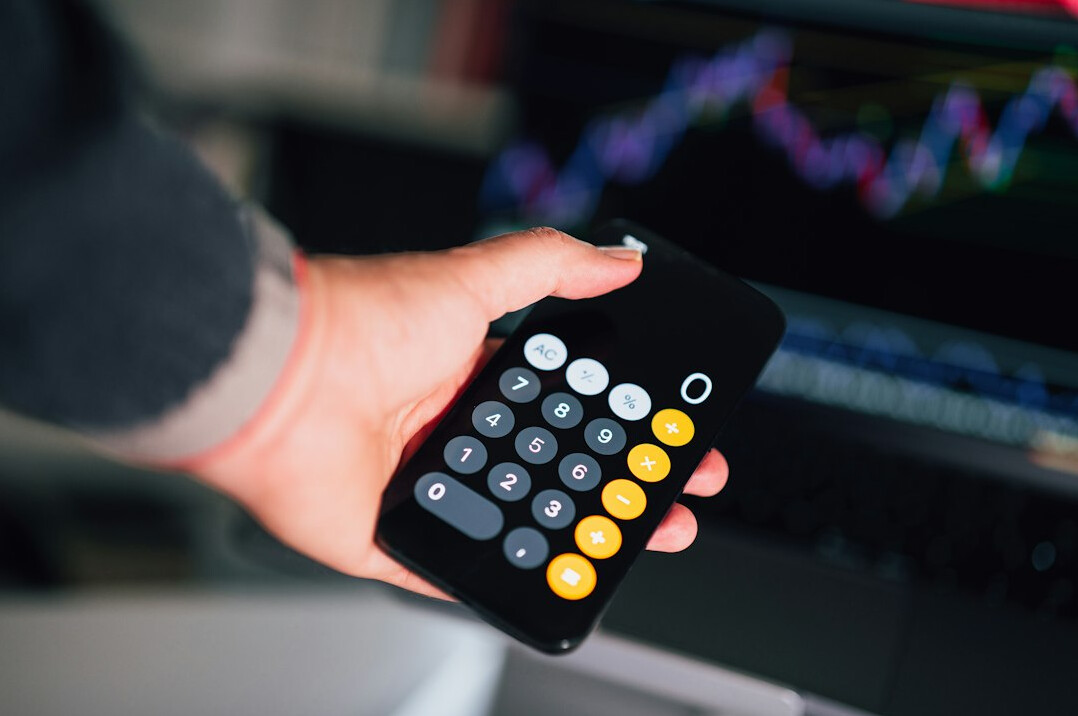 person using calculator for budget
